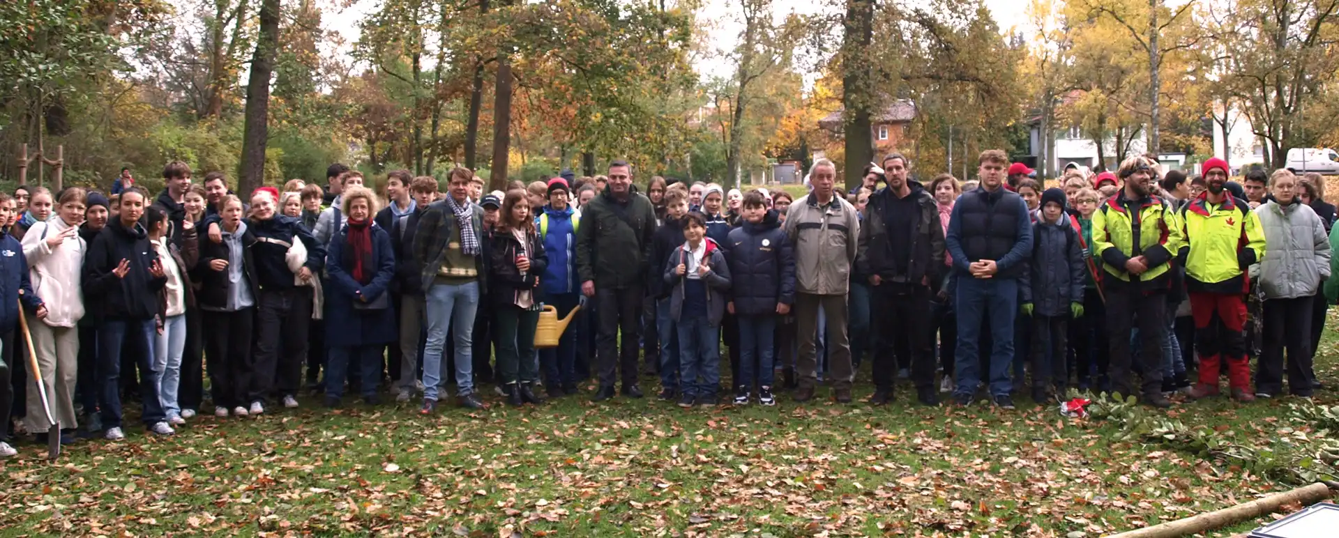 große Gruppe von SchülerInnen, Erwachsenen und Baumpflegern